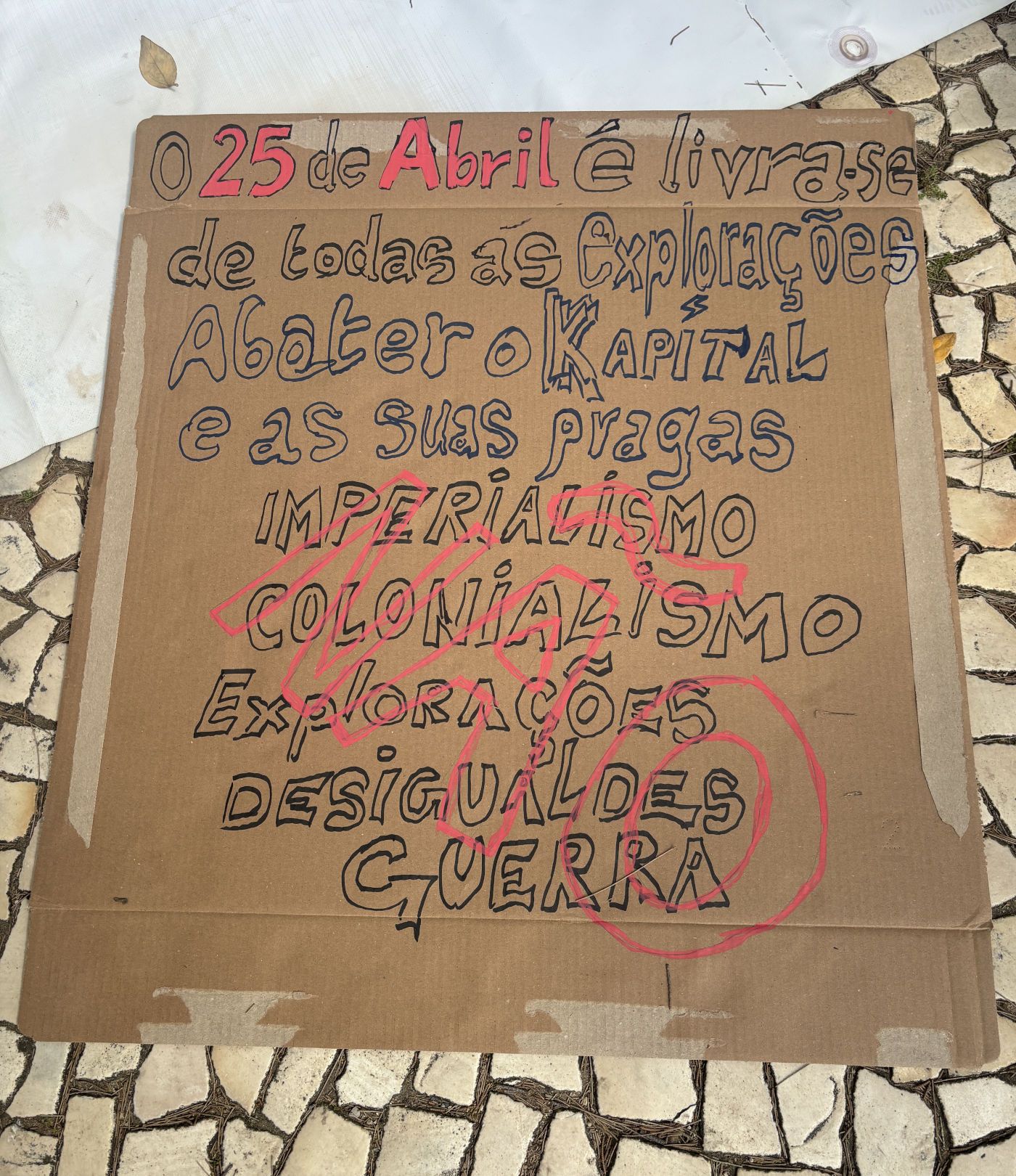 Um cartaz com longas reinvidicações para abril, entre as quais acabar com o Capitalismo e o Colonialismo.